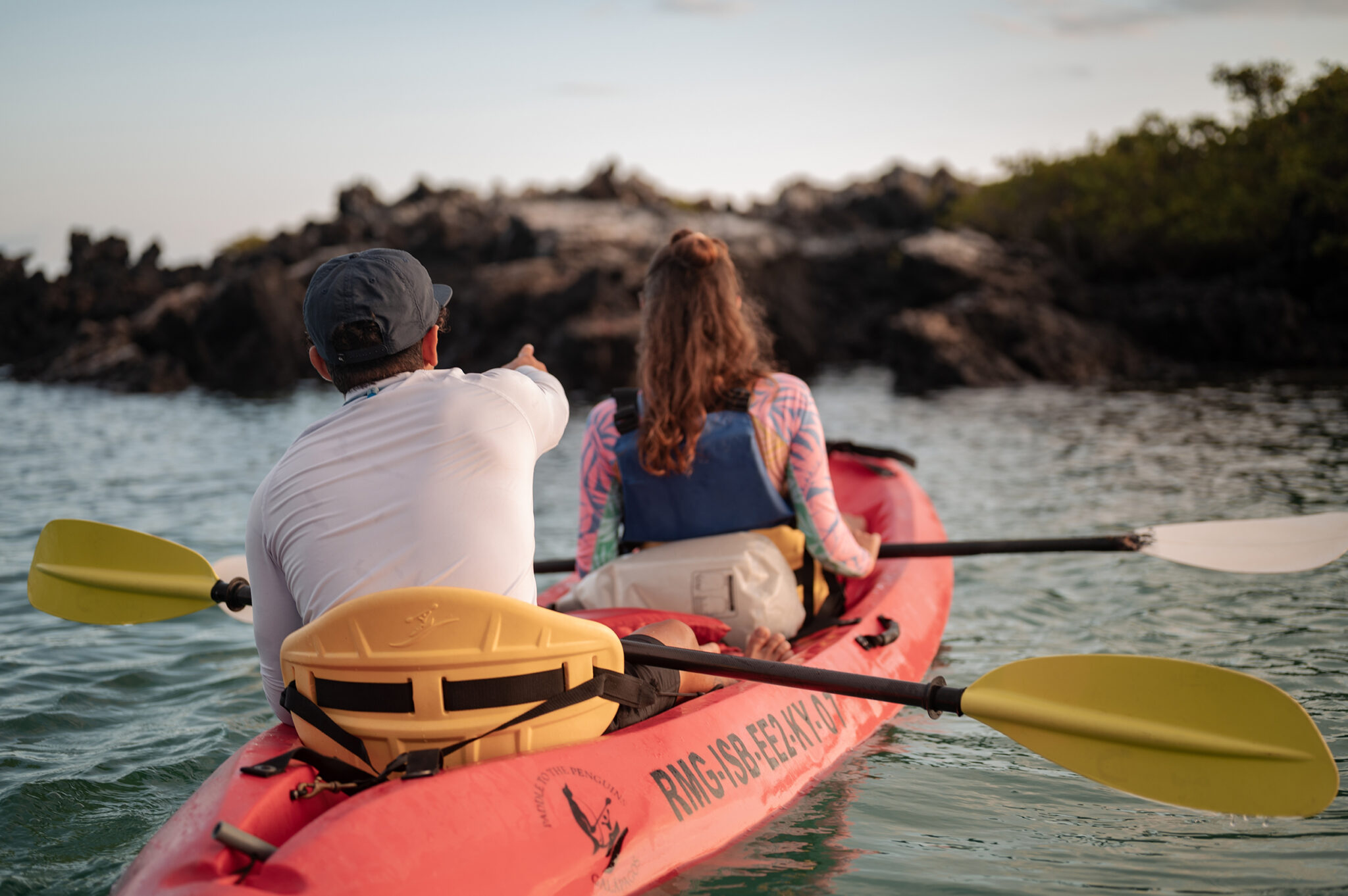 Kayaking around the Galapagos Islands Two paddlers pointing at wildlife in the Galapagos Islands, one of the best places to go kayaking and diving on the same trip