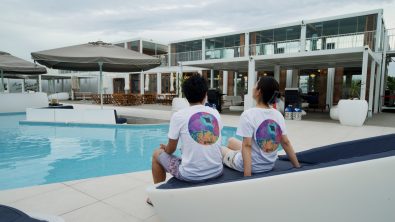 two person wearing a t shirt with colourful coral designs made by PAD Gear as a charity T shirt for Green Fins