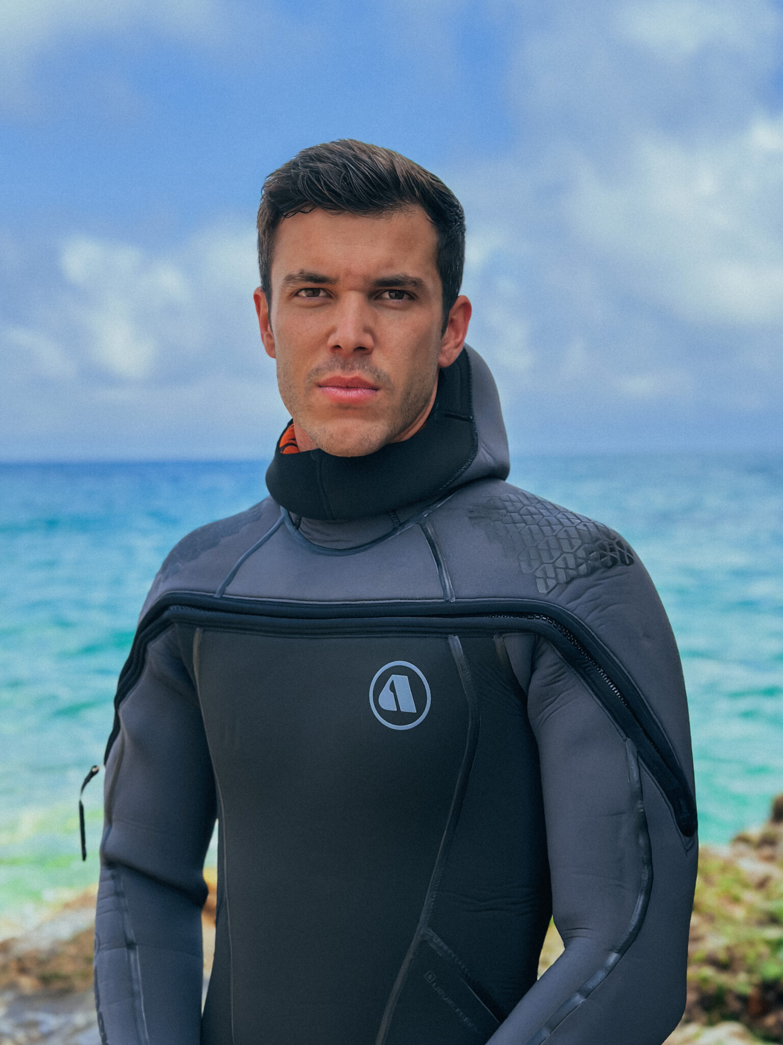 Pol Ramos poses in a wetsuit next to the ocean