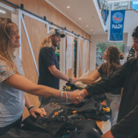 Two PADI Dive Center staff shaking hands with customers who are about to start a new course