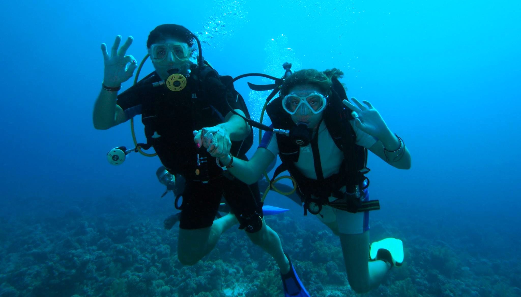 Nikky Weglop and her mother diving underwater holding hands