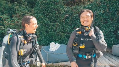 two divers laughing while getting ready for a dive
