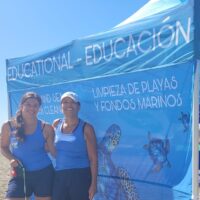 Nikky Weglop and her mother, two PADI Pros, standing in front of an underwater clean up tent