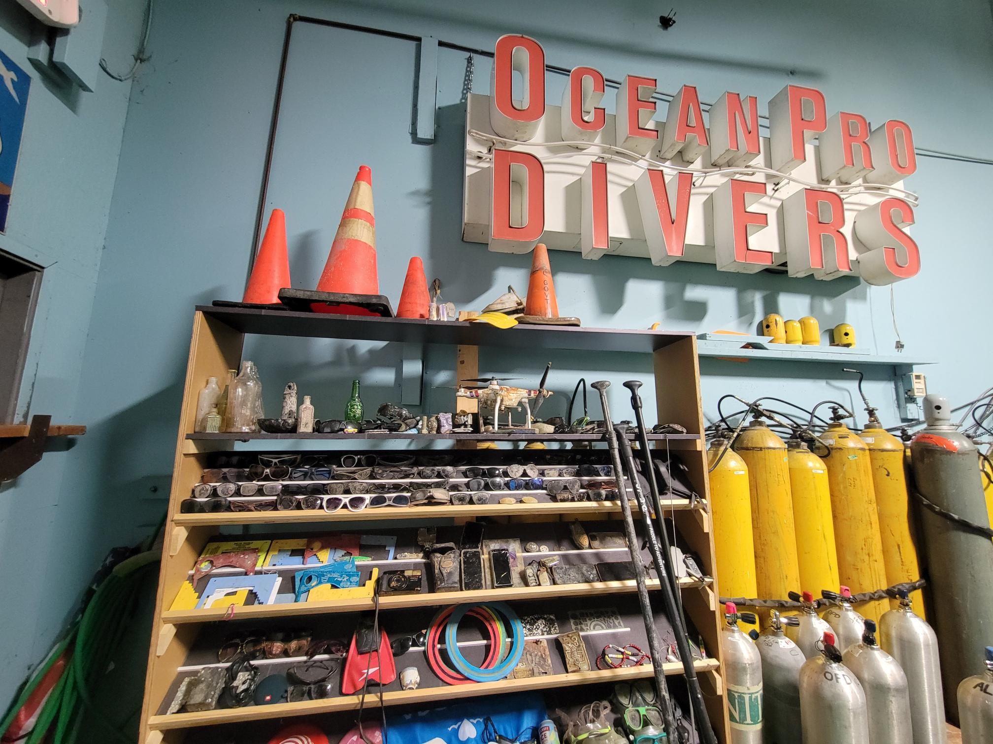 Three shelves full of debris collected from local waterways inside Ocean Pro Divers dive shop 
