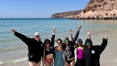 Divers waving on the beach on the LGBTQIA+ Baja Dive Expedition to promote diversity in scuba diving