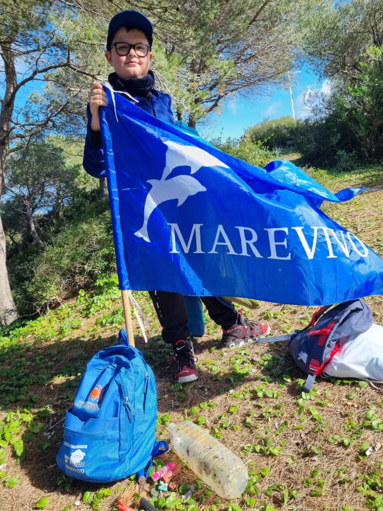 Uno degli studenti del Torchbearer Tatiana Geloso con una bandiera blu per l'iniziativa Marevivo