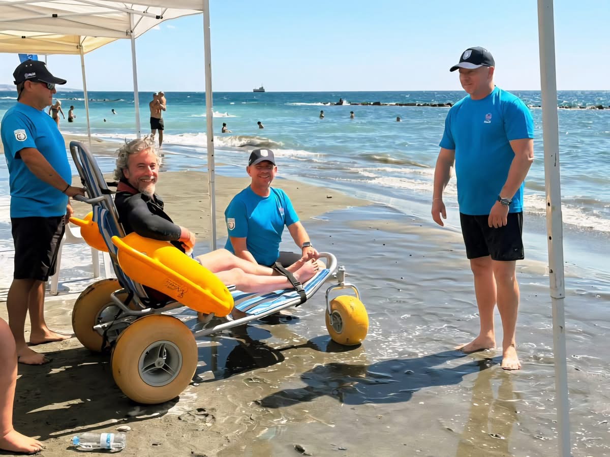 Subacqueo adattato che entra in acqua con una sedia a rotelle da spiaggia per Diving for Peace 2025 a Cipro