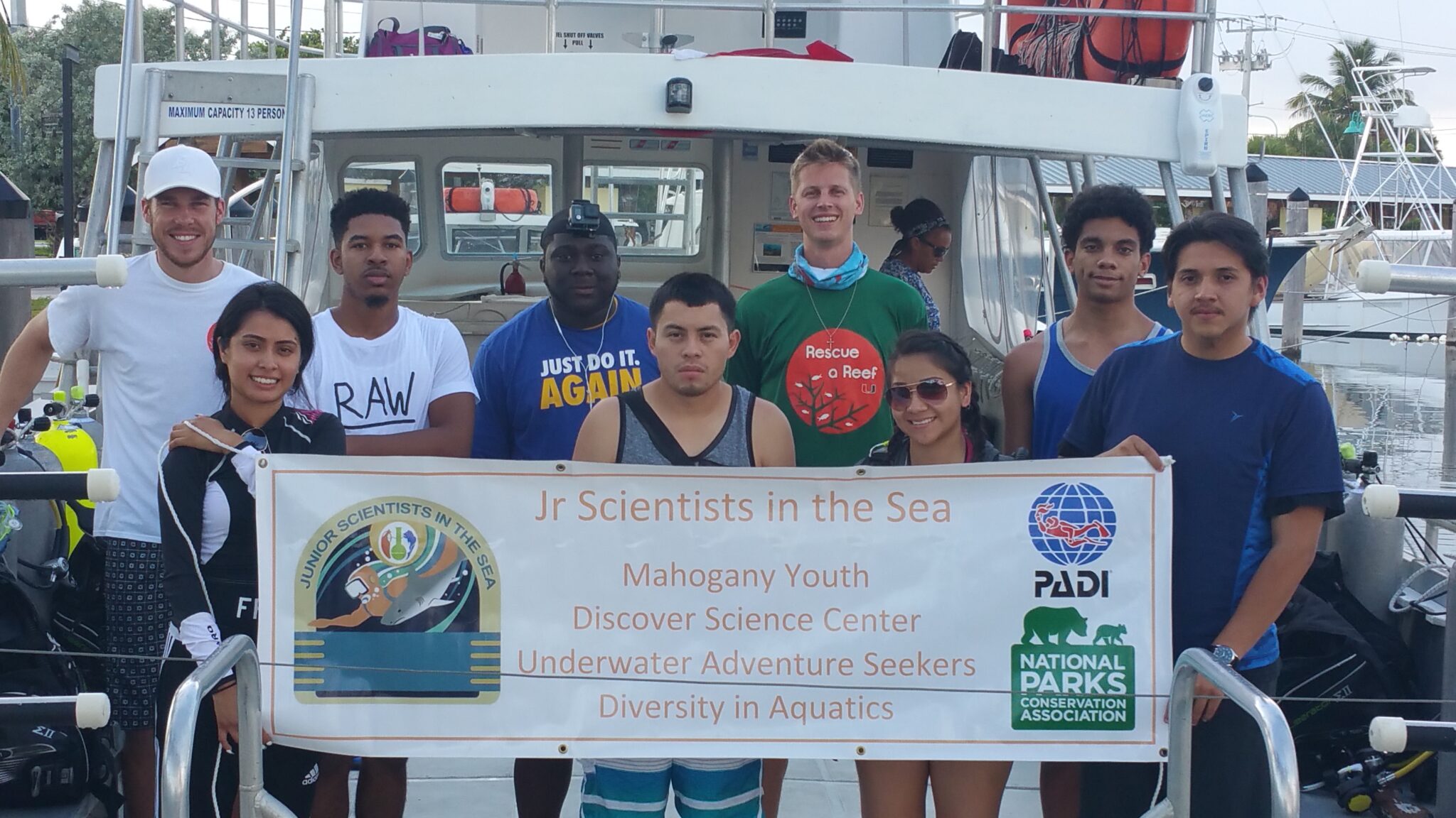 Les Burke- Ocean Torchbearer Award Winner - group of kids holding up a banner for JSIS
