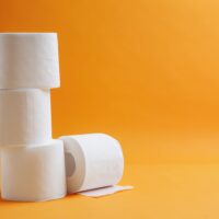 Rolls of toilet paper on color background
