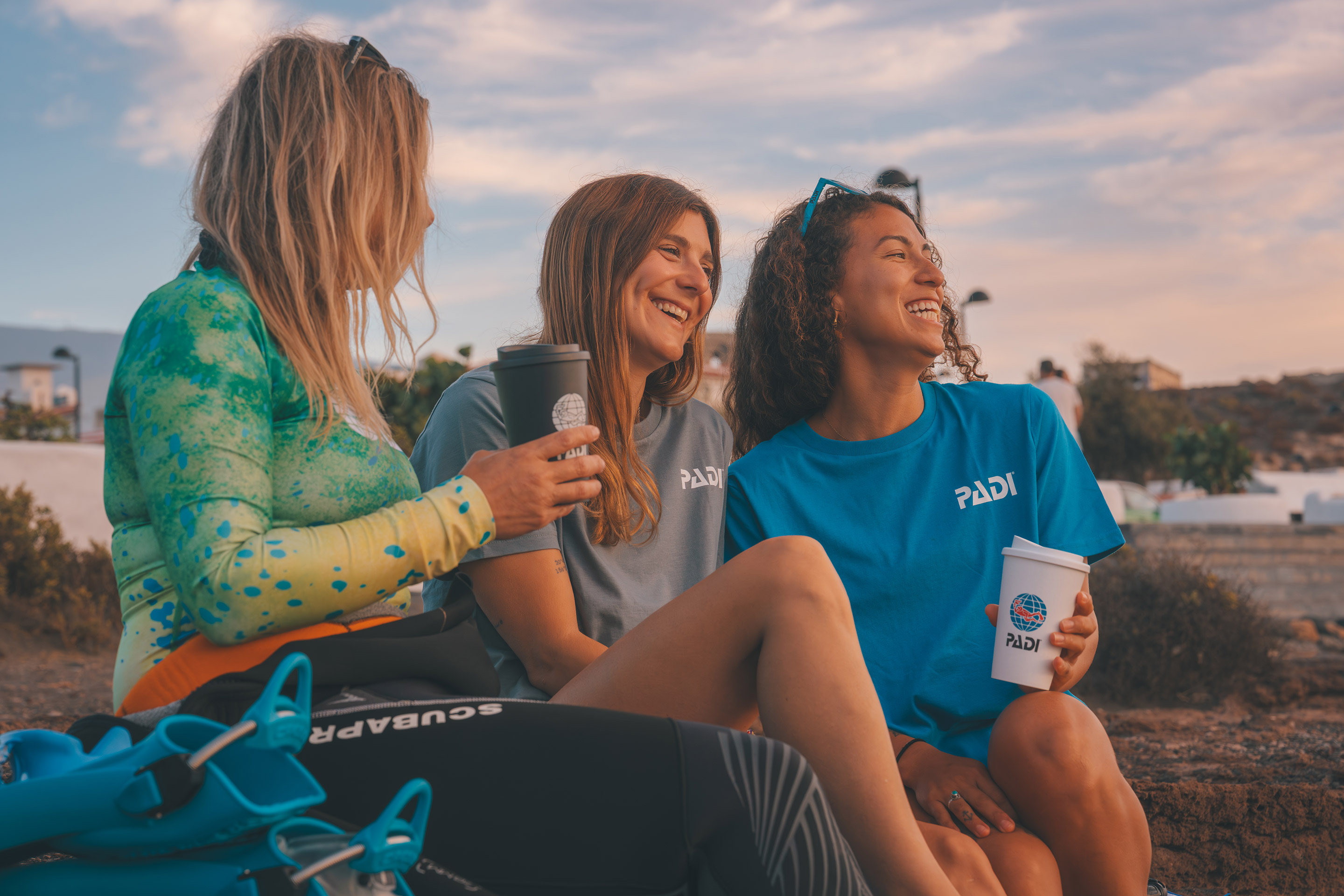 three divers sitting next to each other beach
