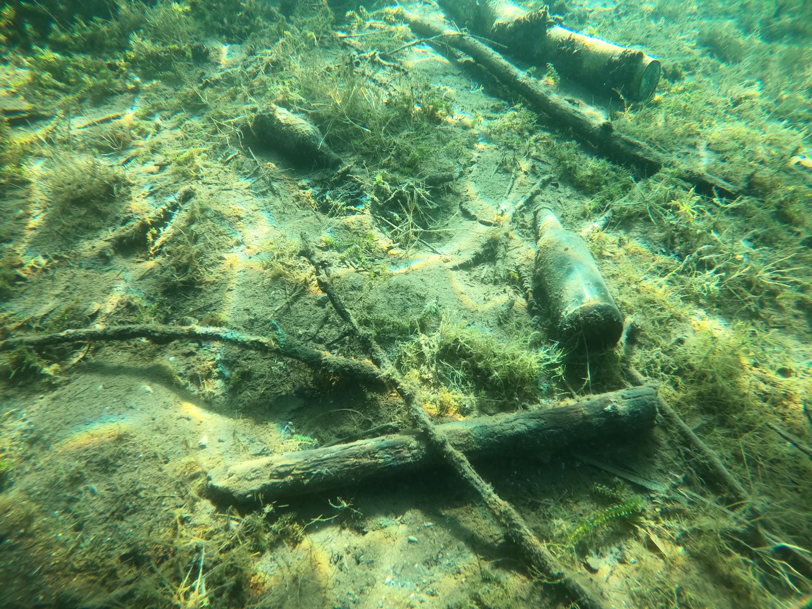 Three glass bottles at the bottom of the lake, some of the trash collected during Dive Against Debris events