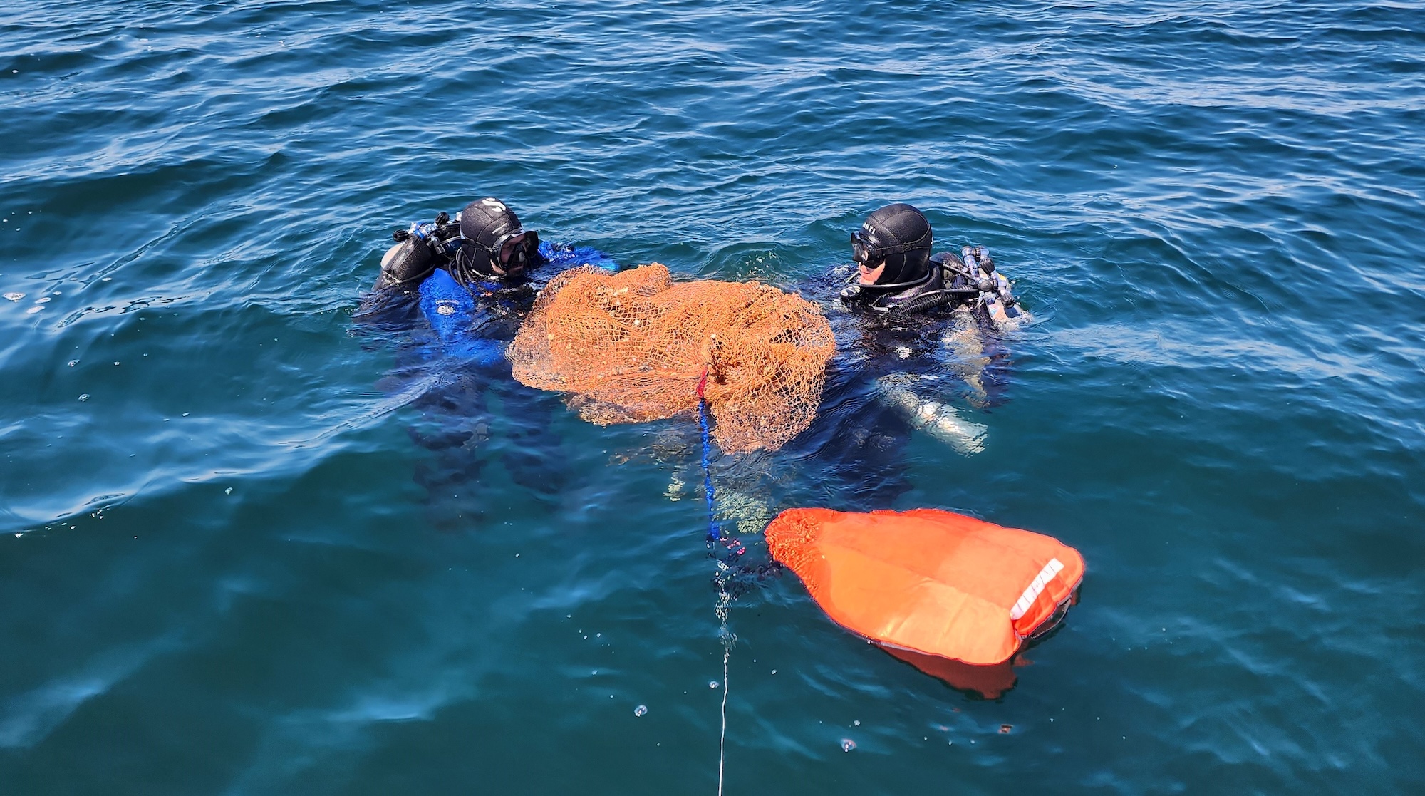 divers with a ghost net in lake erie
