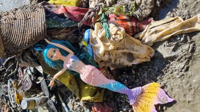 A mermaid doll atop a pile of debris removed from a lake in Switzerland
