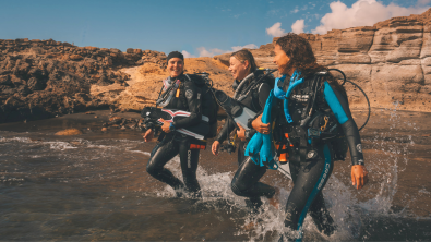 divers walking into water together