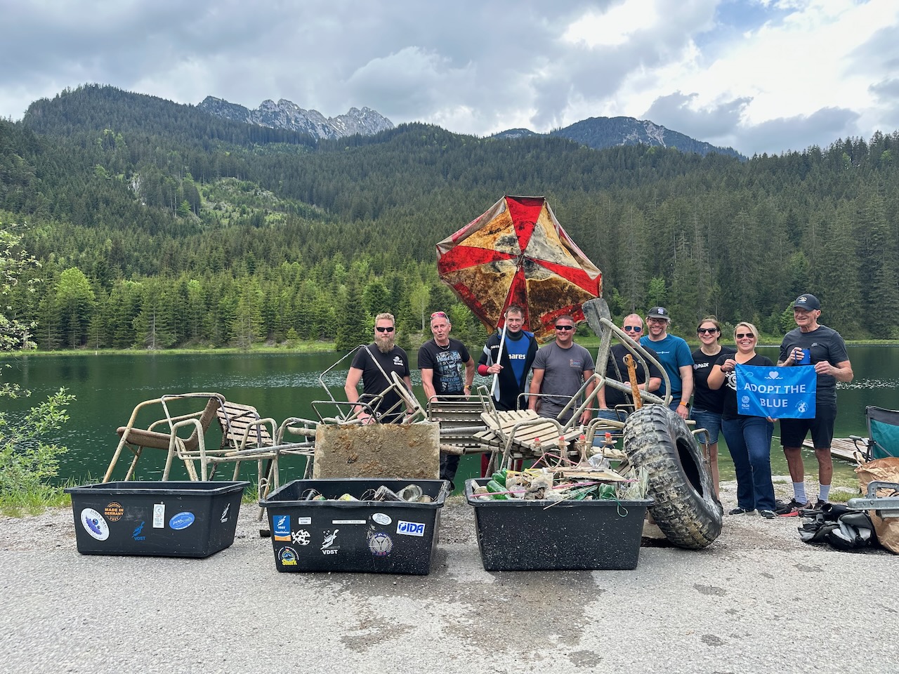 Several cleanup volunteers from diveXellence pose with the trash they collected