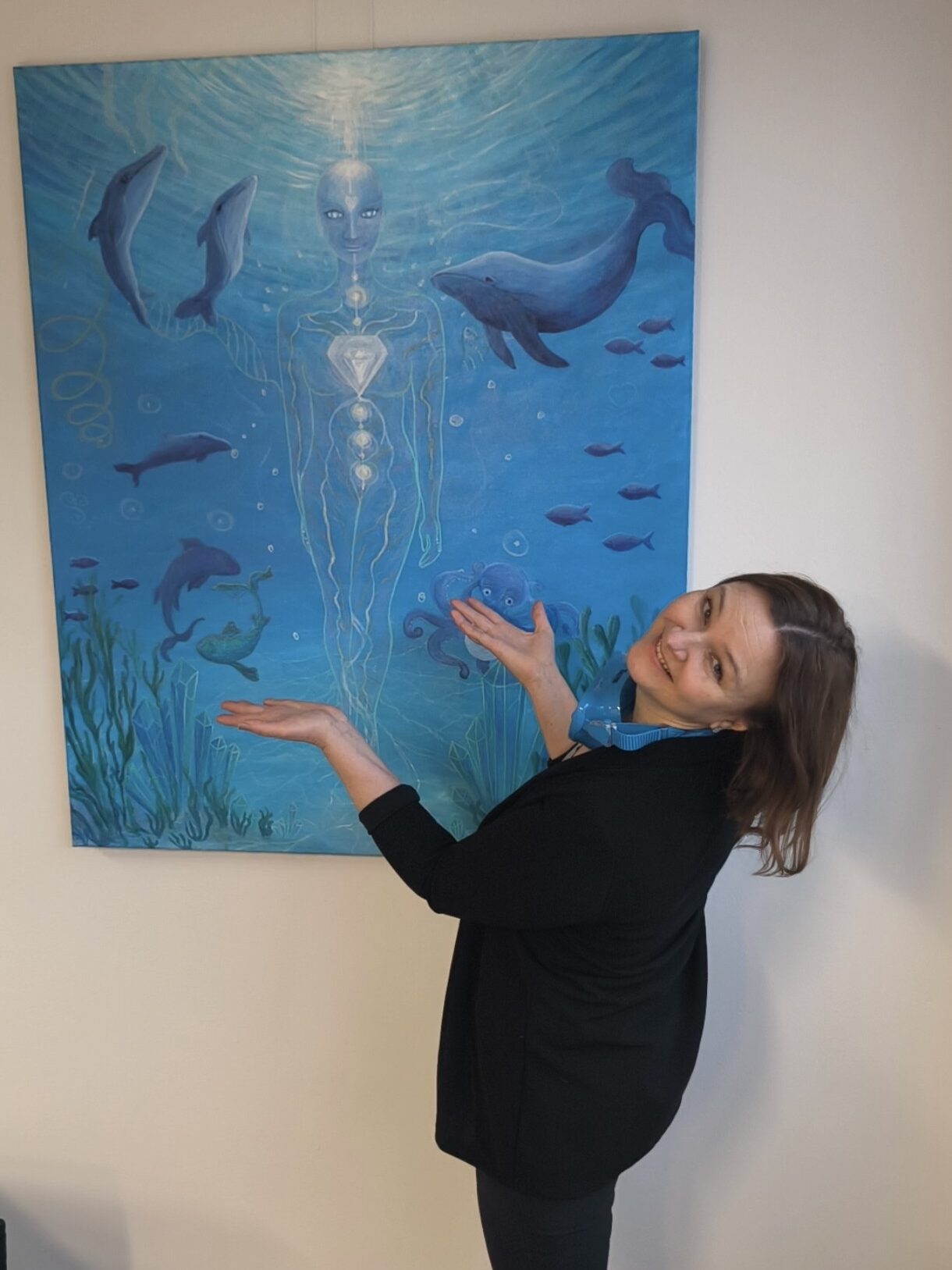 Elena Gushchina (lol2o) showing her ocean inspired artwork hanging on the wall