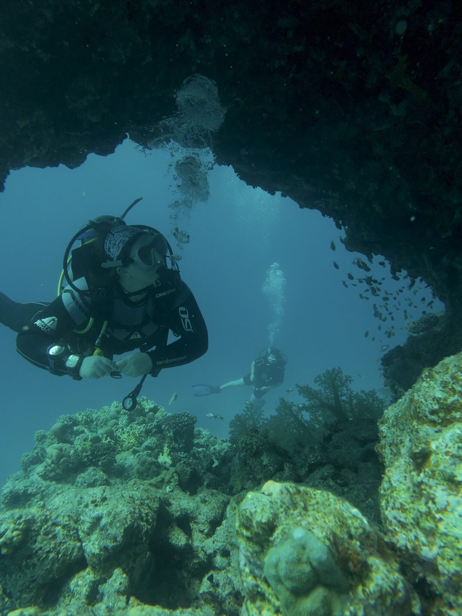 Scuba diver floating under an arch