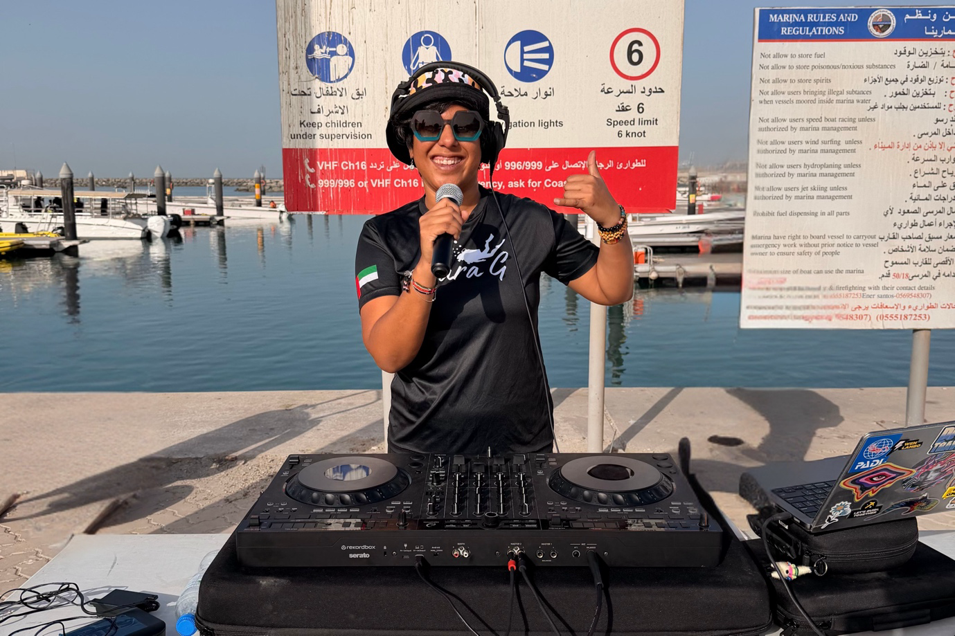 Sara G on a pier with her dj mixing table