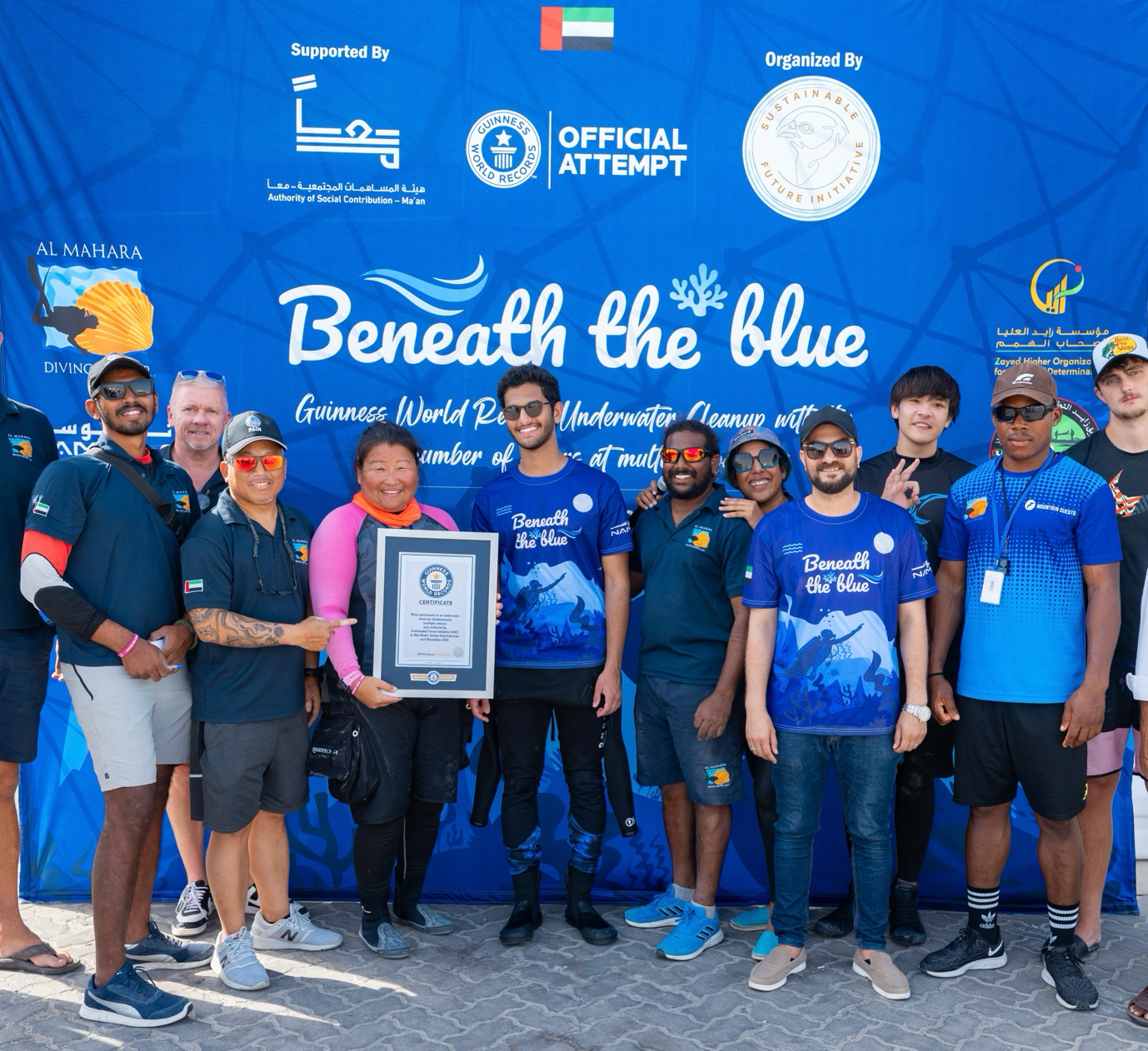 Group photo of the organisers of the Beneath the Blue underwater cleanup showing their Guiness World Record certificate
