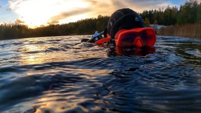 Elena Gushchina (lol2o) in a pink mask and a hood on the surface of a lake in Finland