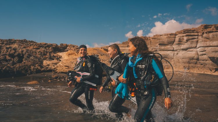 divers entering water buddy check