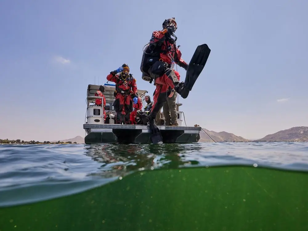 a public safety diver takes a giant step from the back of a boat