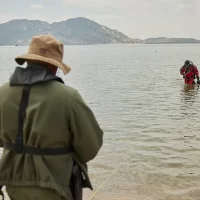 A public safety diver exits the water toward the shore
