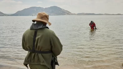A public safety diver exits the water toward the shore