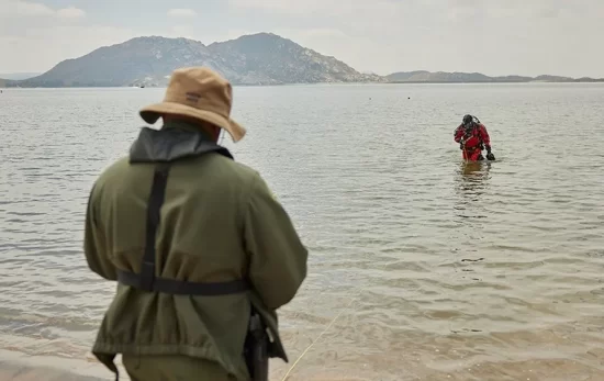 A public safety diver exits the water toward the shore