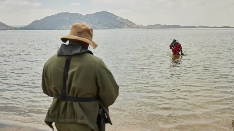 A public safety diver exits the water toward the shore