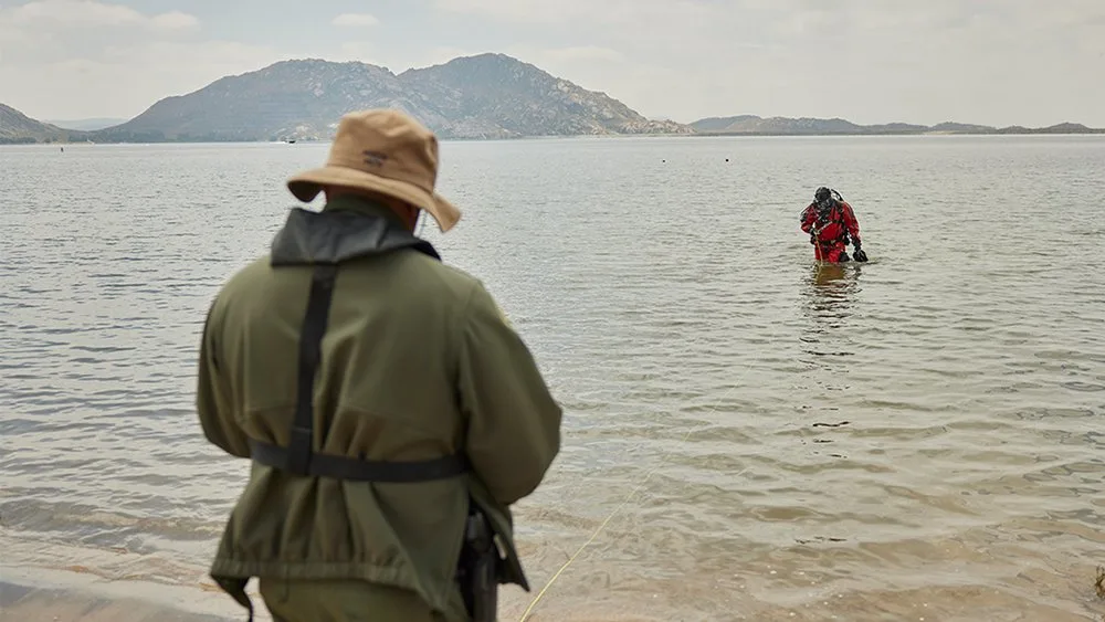 A public safety diver exits the water toward the shore