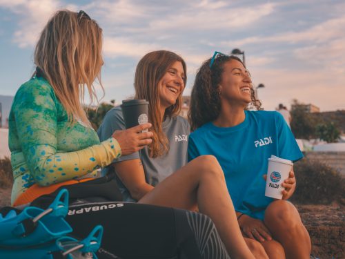 Three divers looking at the sky with reusable cups