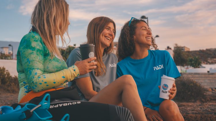 Three divers looking at the sky with reusable cups