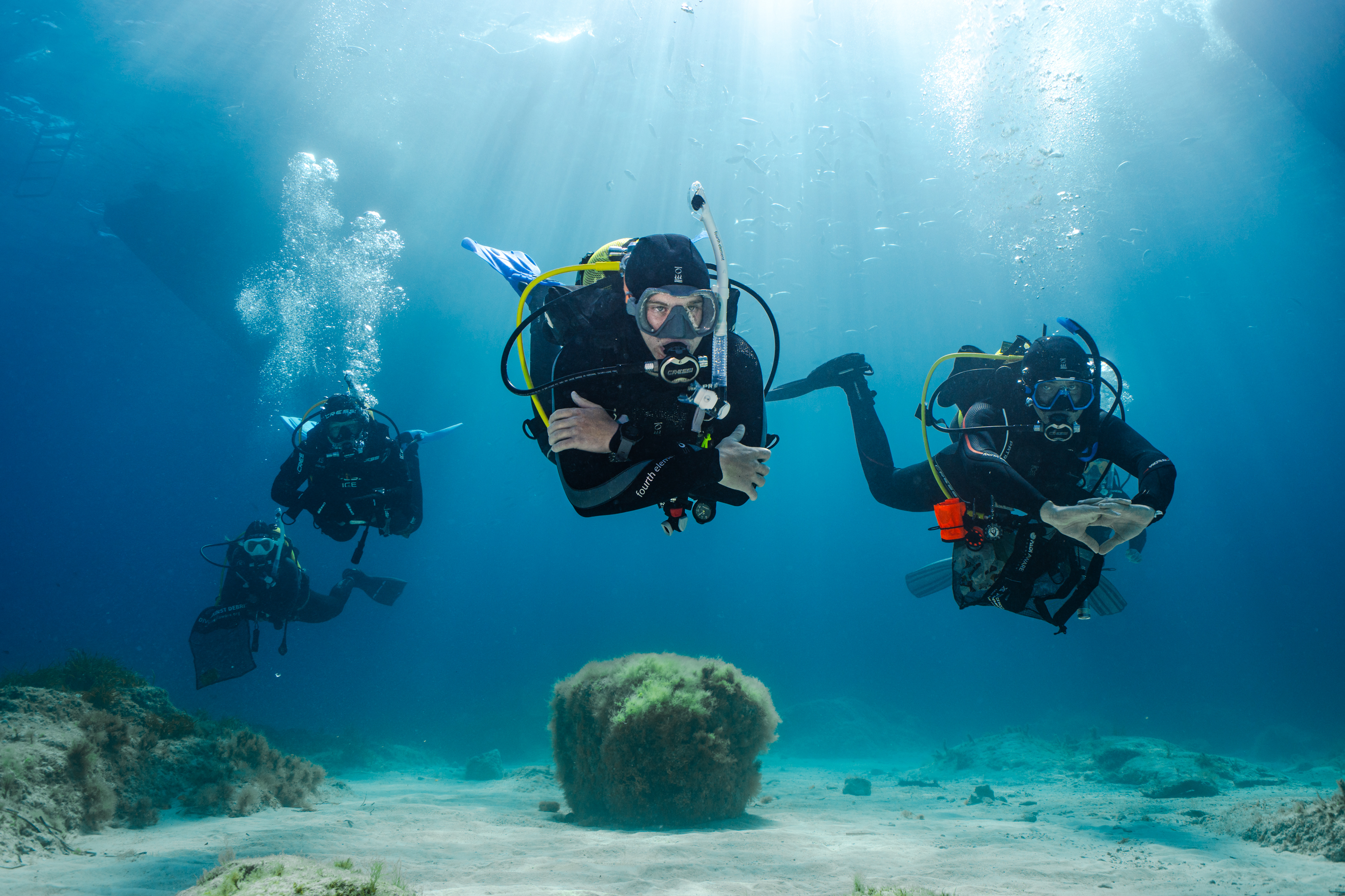5 divers swim underwater in Malta