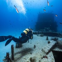 A scuba diver floats over a wreck in Malta