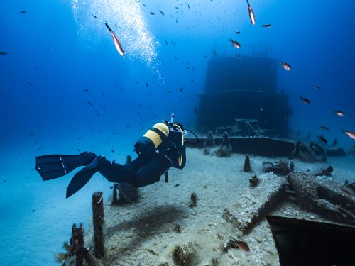 A scuba diver floats over a wreck in Malta