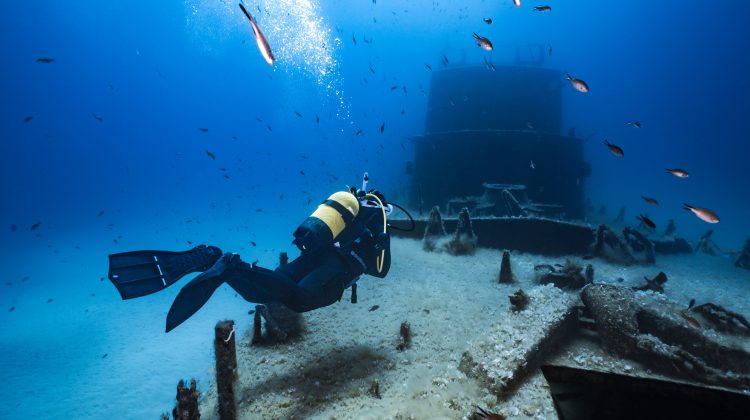 A scuba diver floats over a wreck in Malta