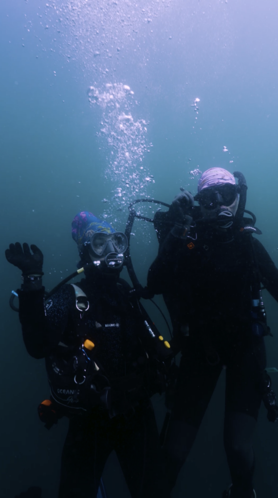 scuba divers dancing underwater