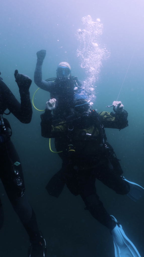 scuba divers dancing underwater