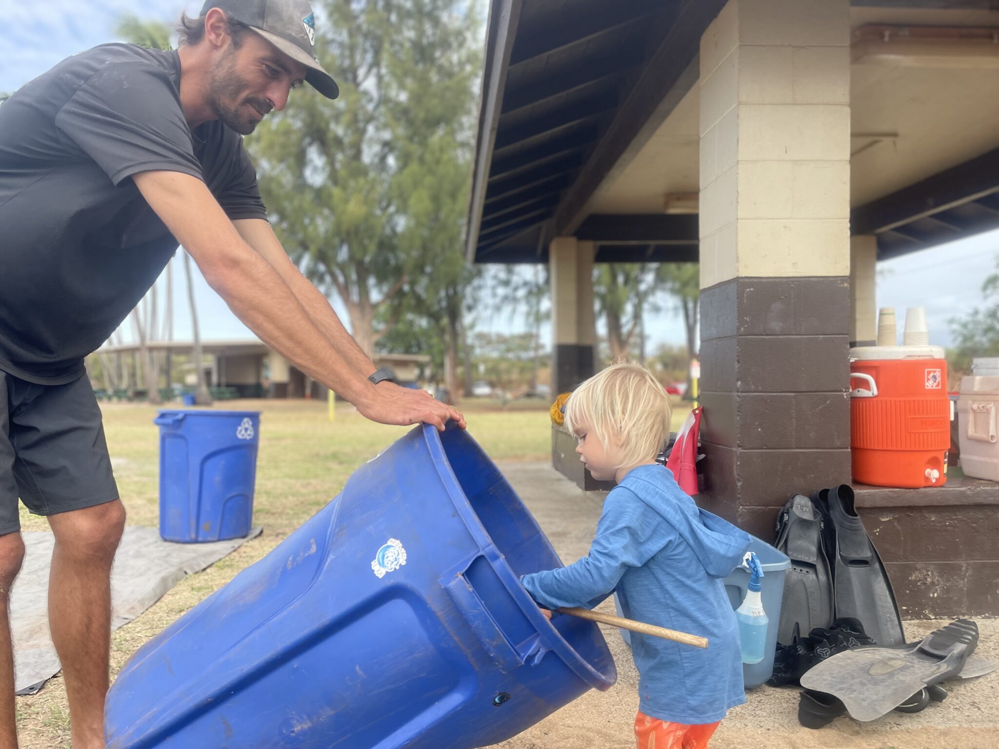PADI Ocean Torchbearer Award winner helps a small child clean out a garbage can