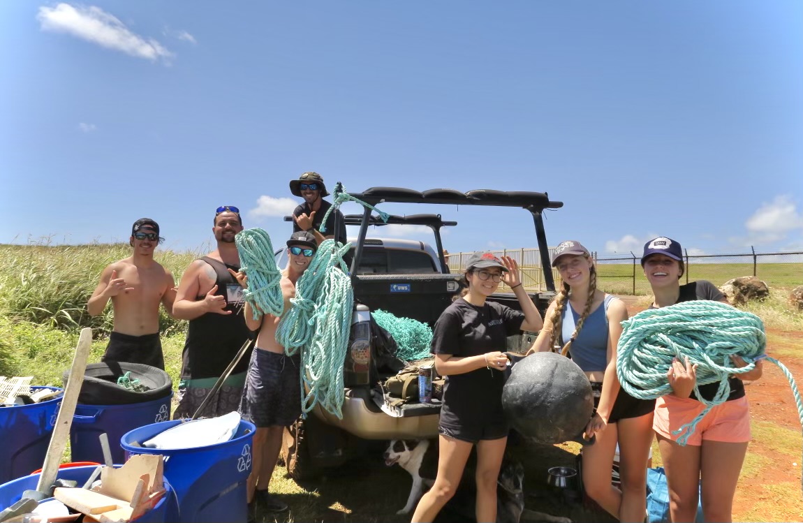 A group of youth unpack supplies from the back of a pick-up truck.