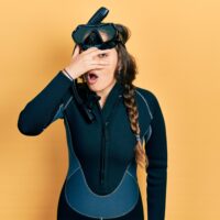 diver looking ashamed on orange background