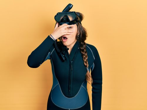 diver looking ashamed on orange background