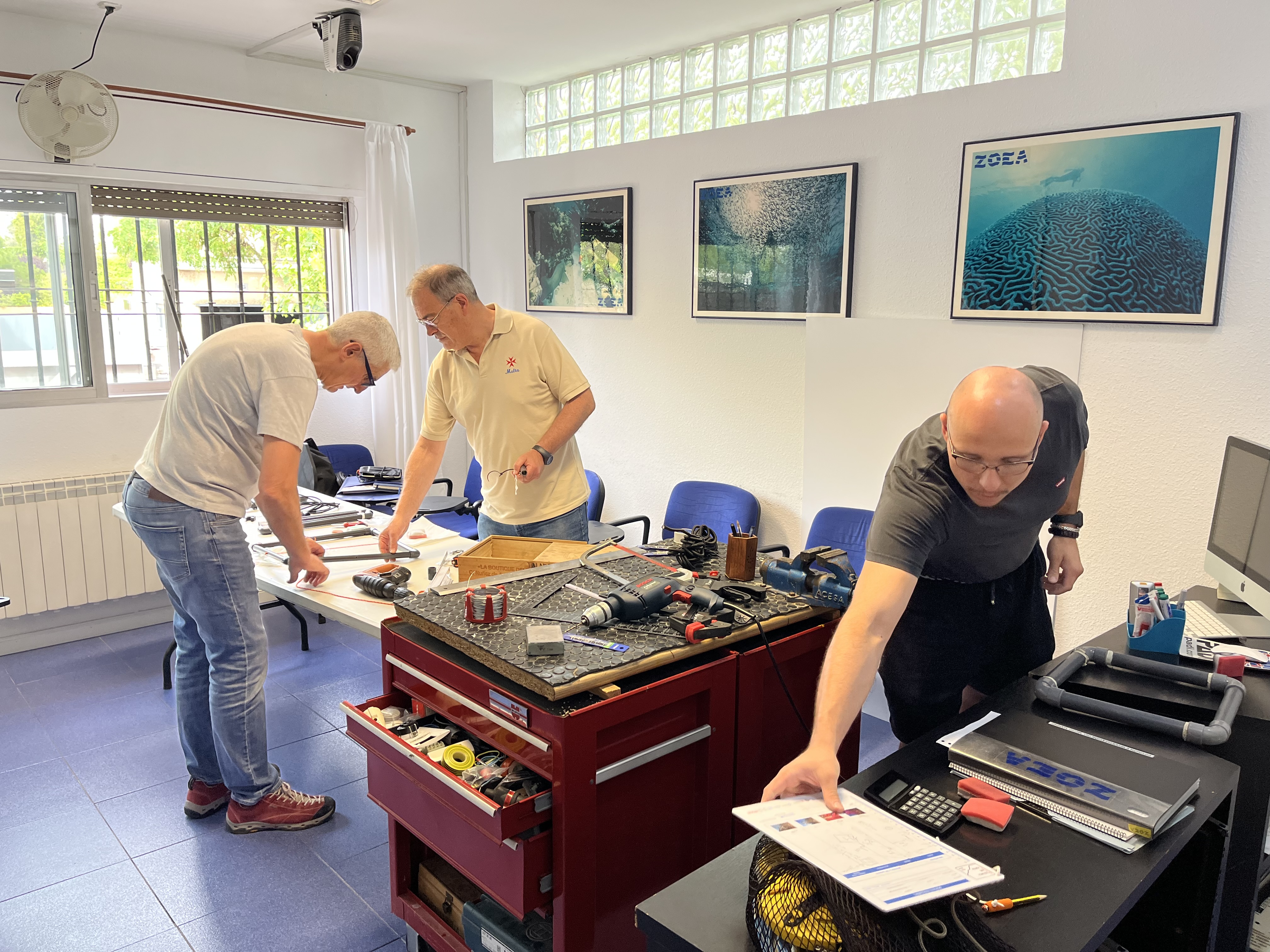 Three scientific divers in a lab getting their gear ready for a field study