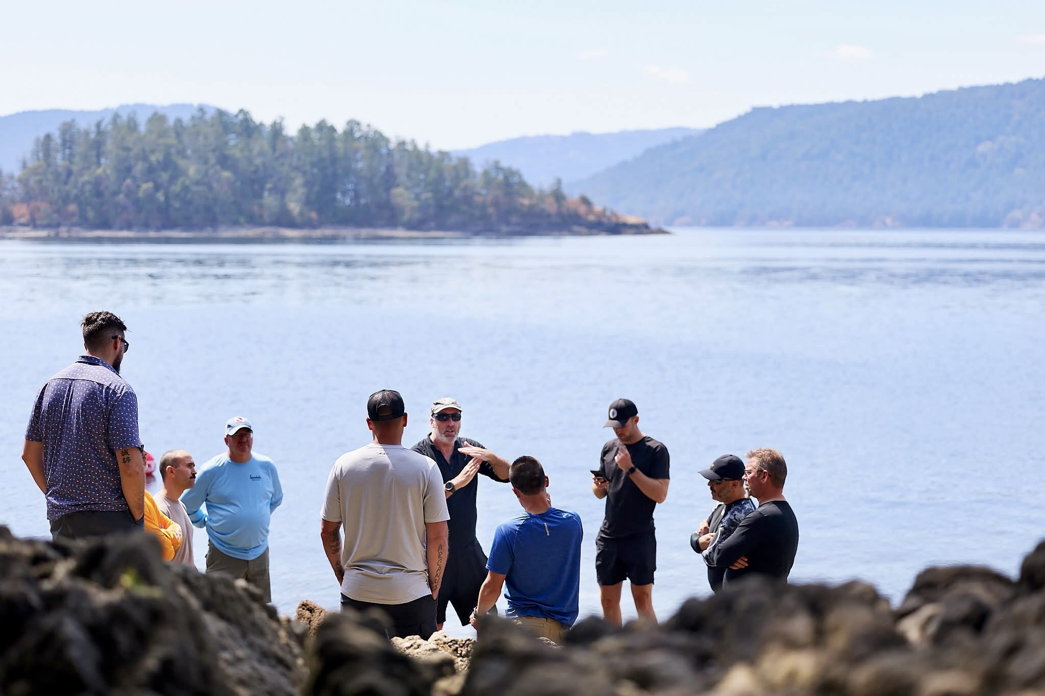 invictus course participants stood next to the water