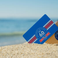 Two certification cards showing PADI's 60th anniversary logo in sand