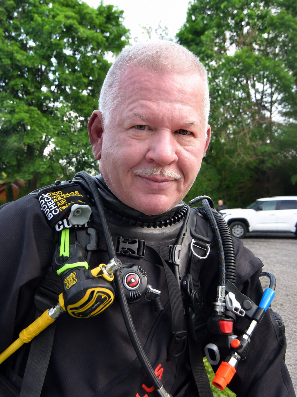 Curt Tomlinson smiles for the camera in a dry suit