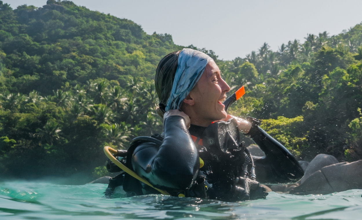 Scuba diver surfacing and smiling post dive.