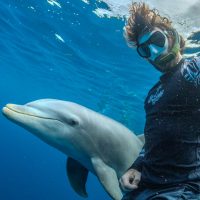 Kellon Spencer, photographer of our limited-edition card design, poses with Becky the dolphin