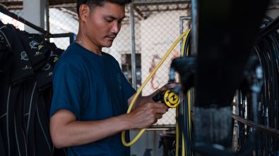 A PADI Pro checking scuba equipment regulators before going diving